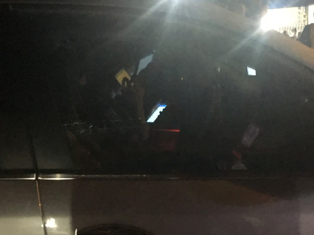 Tài xế ô tô cố thủ trong xe, bấm điện thoại và gọi điện cho người khác.