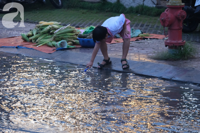 Cậu bé hứng nước để chơi.