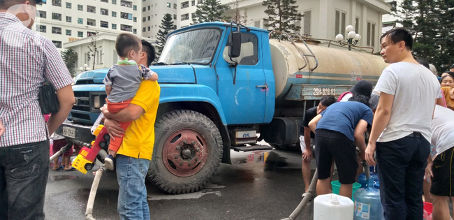 Nhiều người tranh thủ bế theo con nhỏ xuống khu vực lấy nước