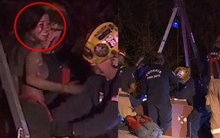 Cô gái tươi cười sau khi được lực lượng cứu hoả đưa ra từ ống khói.