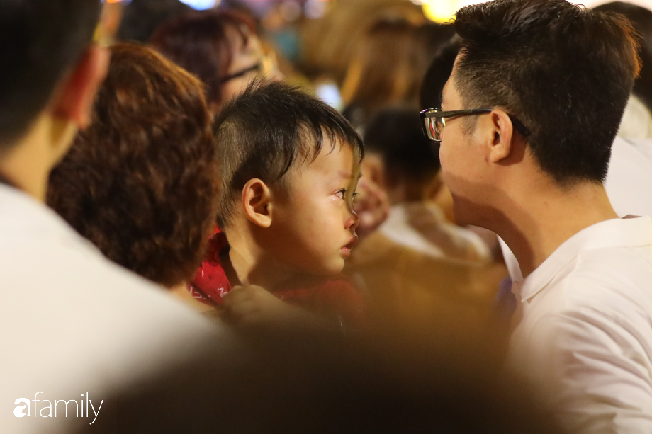 Các em bé cảm thấy mệt mỏi khi phải chen lấn một cách bất đắc dĩ trong dòng người chật kín.