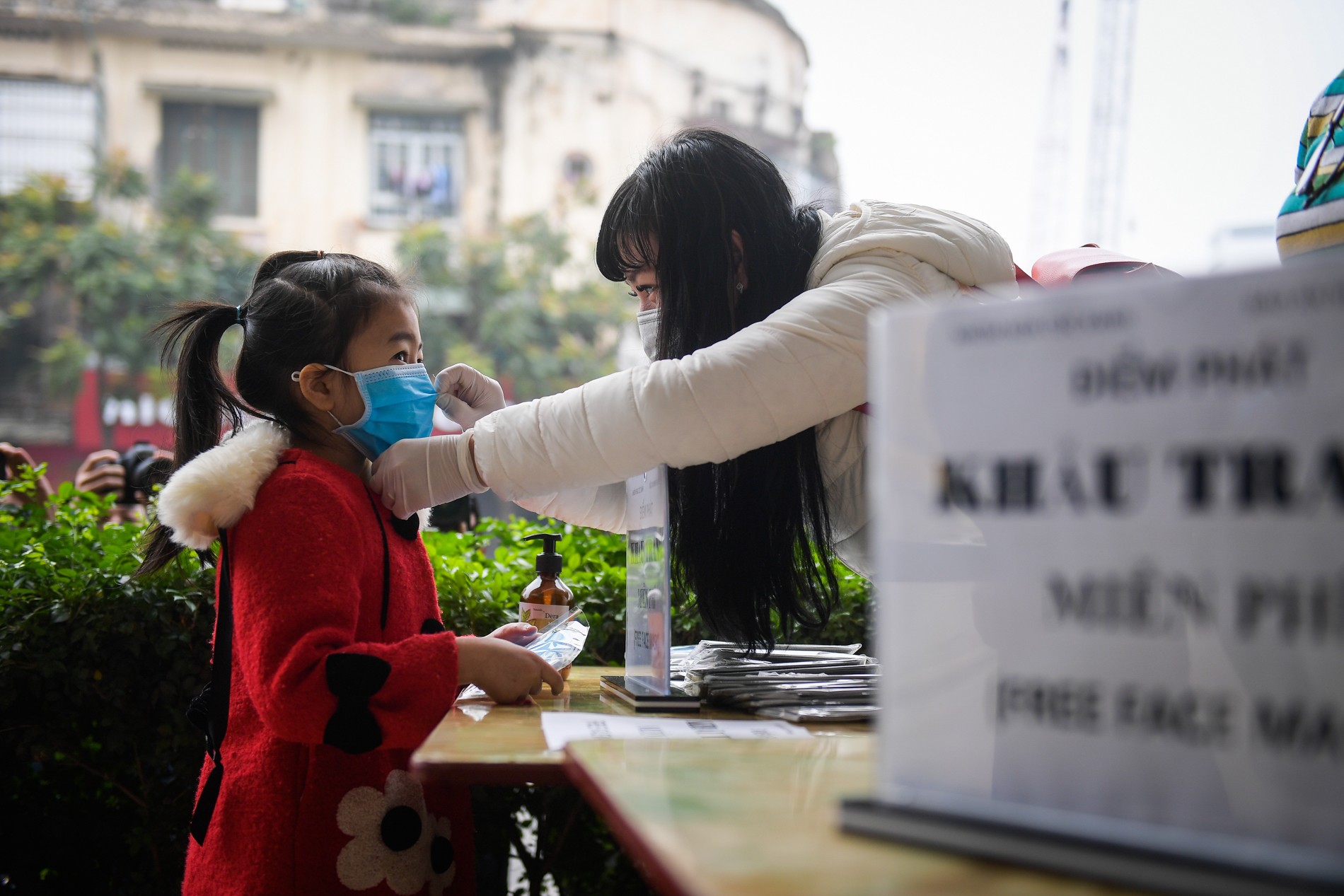 Các tình nguyện viên hướng dẫn tận tình cho các em nhỏ cách đeo khẩu trang đúng cách.