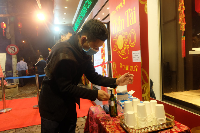 Khách hàng rửa tay sát khuẩn trước khi vào mua vàng.