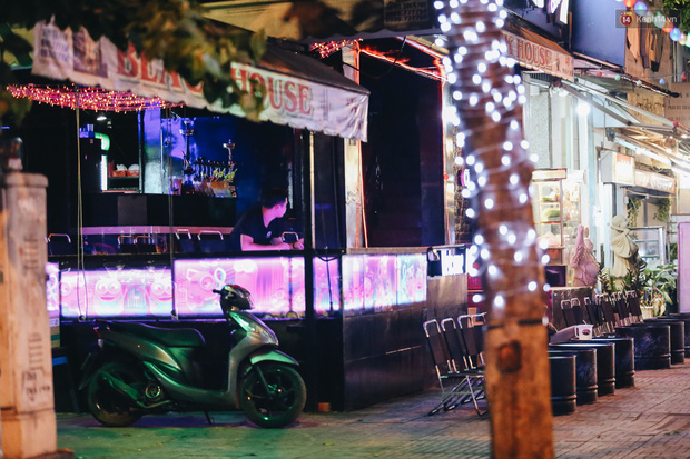 Chủ quán bia ngồi nhìn ra đường chờ khách từ chiều đến gần khuya nhưng chờ mãi chẳng thấy.