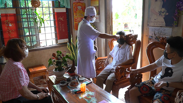 Cán bộ y tế kiểm tra thân nhiệt và sức khoẻ của những người cách ly tại nhà. (Ảnh minh hoạ)