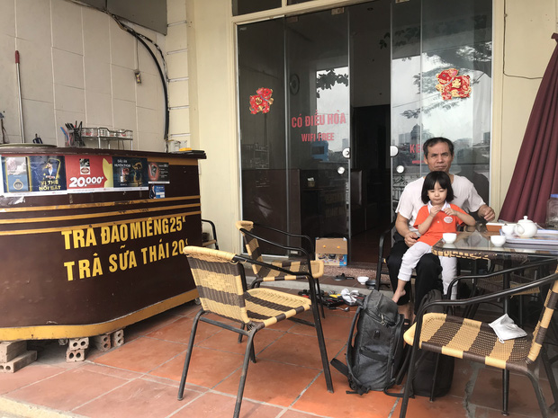 Ông Từ ngồi trông cháu ngoài cửa nhà kiêm mở quán cafe nay đã đóng cửa.