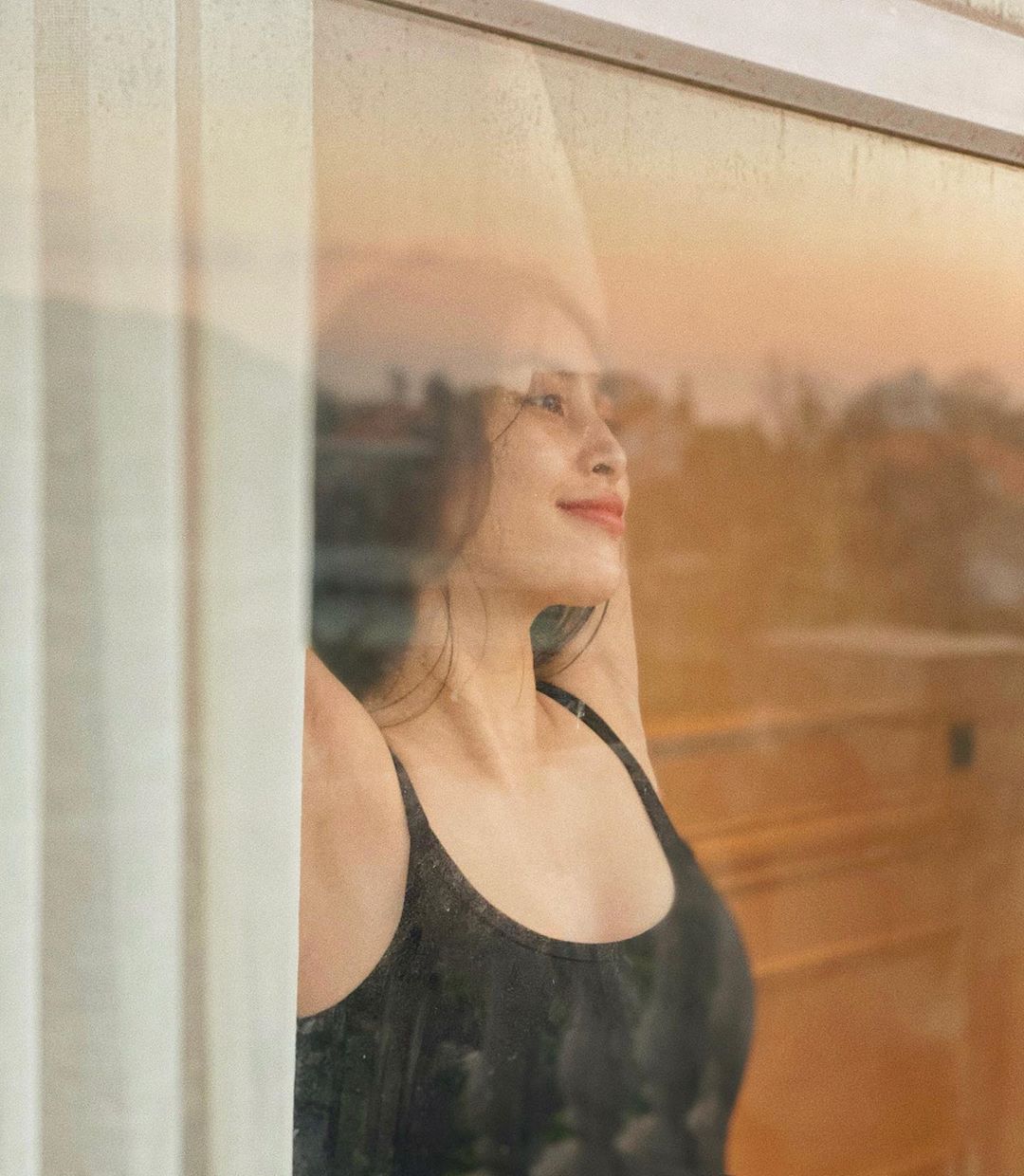 Khi hoàng hôn buông xuống, Tiểu Vy đã nhanh tay ghi lại khoảnh khắc ngọt ngào mà không kém phần gợi cảm của mình bên ô cửa sổ. Nàng Hậu khoe nhan sắc mộc mạc nhưng đẹp mơn mởn trong bộ đầm đem ôm sát, mái tóc xõa nhẹ nhàng đủ khiến bao con tim loạn nhịp.