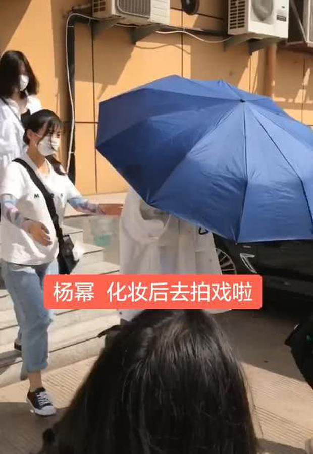 Nữ diễn viên lấy ô che kín mặt, bước thật nhanh về phía xe, để trợ lý phải chạy theo