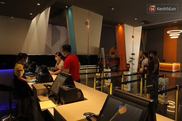 Khách hàng giữ đúng khoảng cách khi mua vé, nhân viên cũng đeo khẩu trang và dụng cụ che chắn đầy đủ