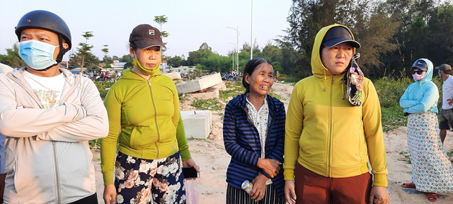 Gia đình nạn nhân Đoàn Nguyễn Nhân Hiếu (27 tuổi) thẫn thờ đứng trên bờ ngóng trông tin tức. Ảnh: Lê Vương