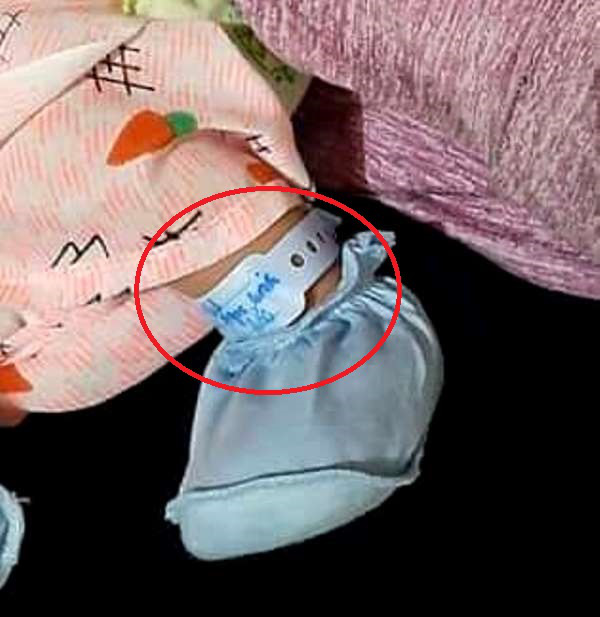 Dải lụa ghi họ tên cháu bé cùng mẹ đẻ được quấn vào chân trái của bé trai. Ảnh: Bạn đọc cung cấp