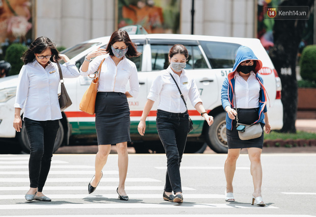 Tại TP HCM, người dân, nhân viên văn phòng tuân thủ đeo khẩu trang khi ra ngoài đường.