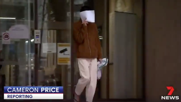 Lê Bảo Trung che mặt sau khi rời khỏi toà án Parramatta Bail Court vào 8/8. (Ảnh chụp từ bản tin của 7NEWS Sydney)