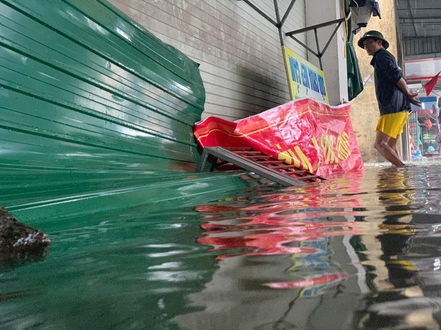 Một vài hộ dân dùng tôn và biển báo để chắn nước vào nhà