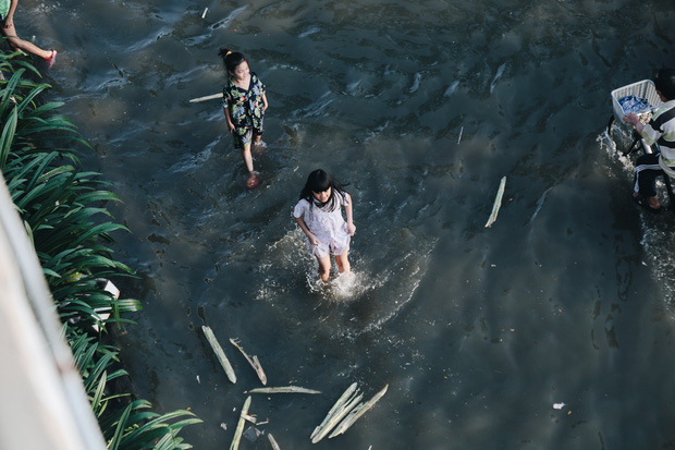 Trẻ em đùa giỡn trên đường ngập vì triều cường