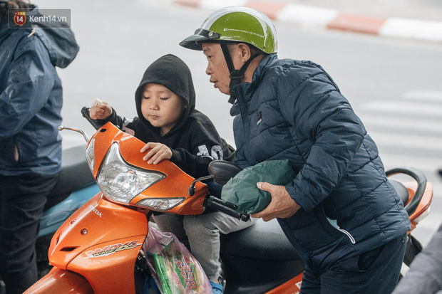 Người dân trú mưa dưới chân cầu vượt. (Ảnh: Minh Nhân)