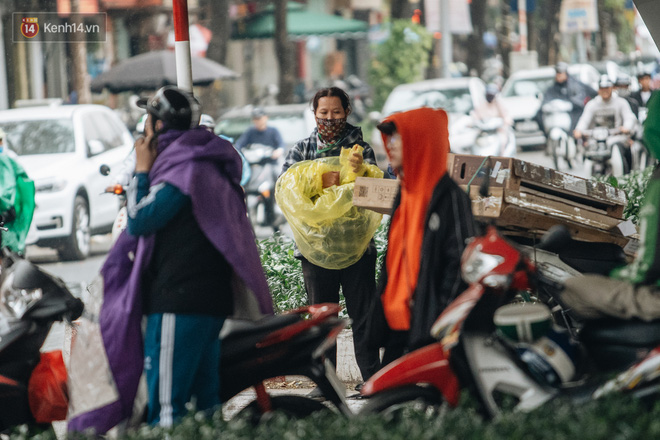 Người dân mặc áo mưa vừa để tránh mưa vừa để đỡ rét. (Ảnh: Minh Nhân)