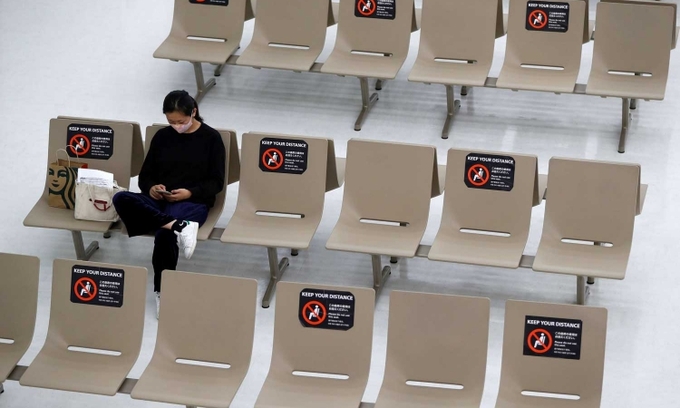 Một phu nữ ngồi chờ ở sân bay quốc tế Narita, Nhật Bản, hôm 2/11. Ảnh: Reuters.