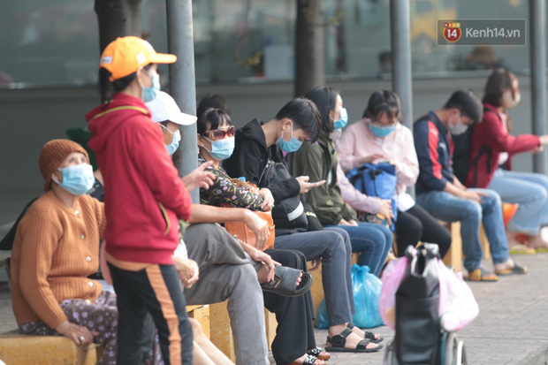 Nhiều người mệt mỏi ngồi chờ xe buýt (Ảnh: Tứ Quý)