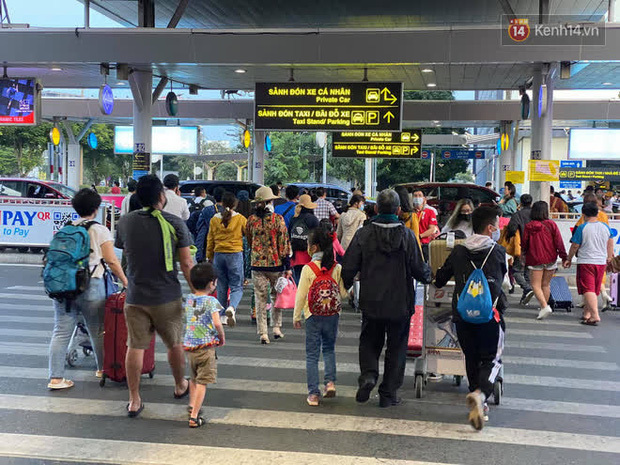 Nhiều hành khách, trong đó có những gia đình với hành lý lỉnh kỉnh, vội vã ra đón xe về nhà sau khi đáp chuyến bay (Ảnh: Tứ Quý)