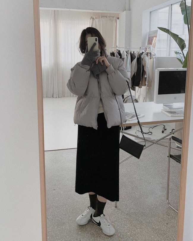 Đừng chỉ mix áo phao với quần dài, bộ đôi áo phao + chân váy cũng vô cùng đẹp mắt, trẻ trung và nữ tính. Hãy ưu tiên váy dáng suông vì khi mix với áo phao, bạn sẽ có được outfit gọn ghẽ, tôn dáng.