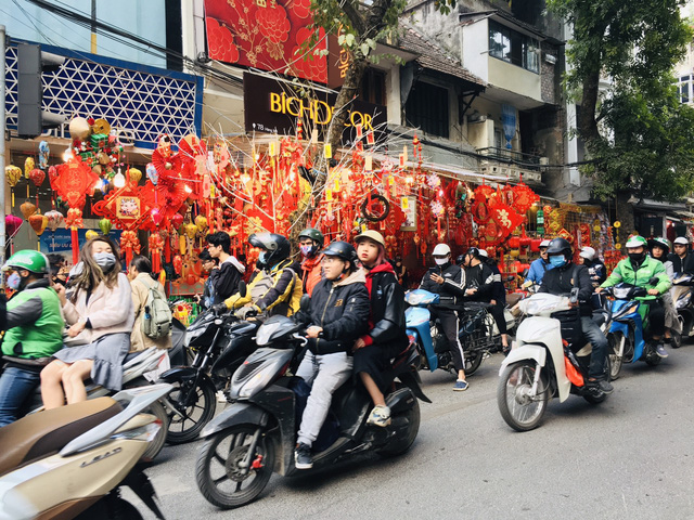 Khung cảnh tấp nập, sôi động. Cả con phố được bao phủ bởi sắc đỏ lung linh, rực rỡ của hàng trăm mặt hàng trang trí phục vụ ngày Tết.