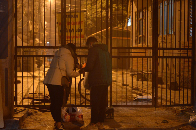 Người thân tới đưa đồ tiếp tế qua khe cửa.