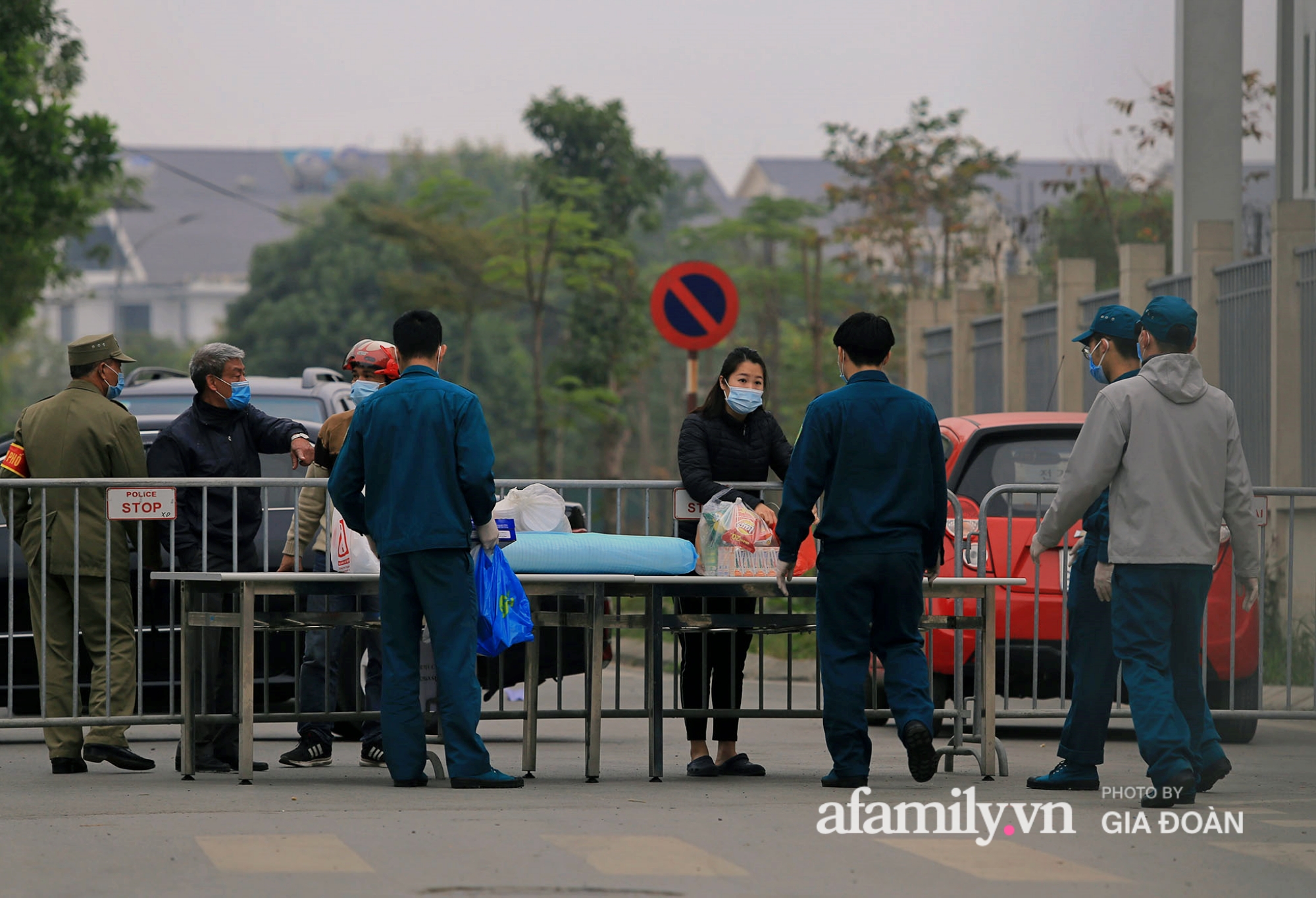 Những người gửi đồ ăn, vật dụng cá nhân vào trường được lực lượng dân phòng hỗ trợ khử khuẩn, đưa vào bên trong.