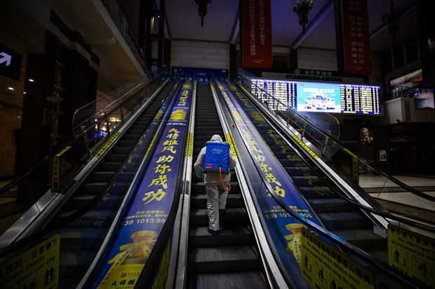 Một nhân viên phòng chống dịch khử khuẩn thang máy ở ga tàu Bắc Kinh. Ảnh: People Visual