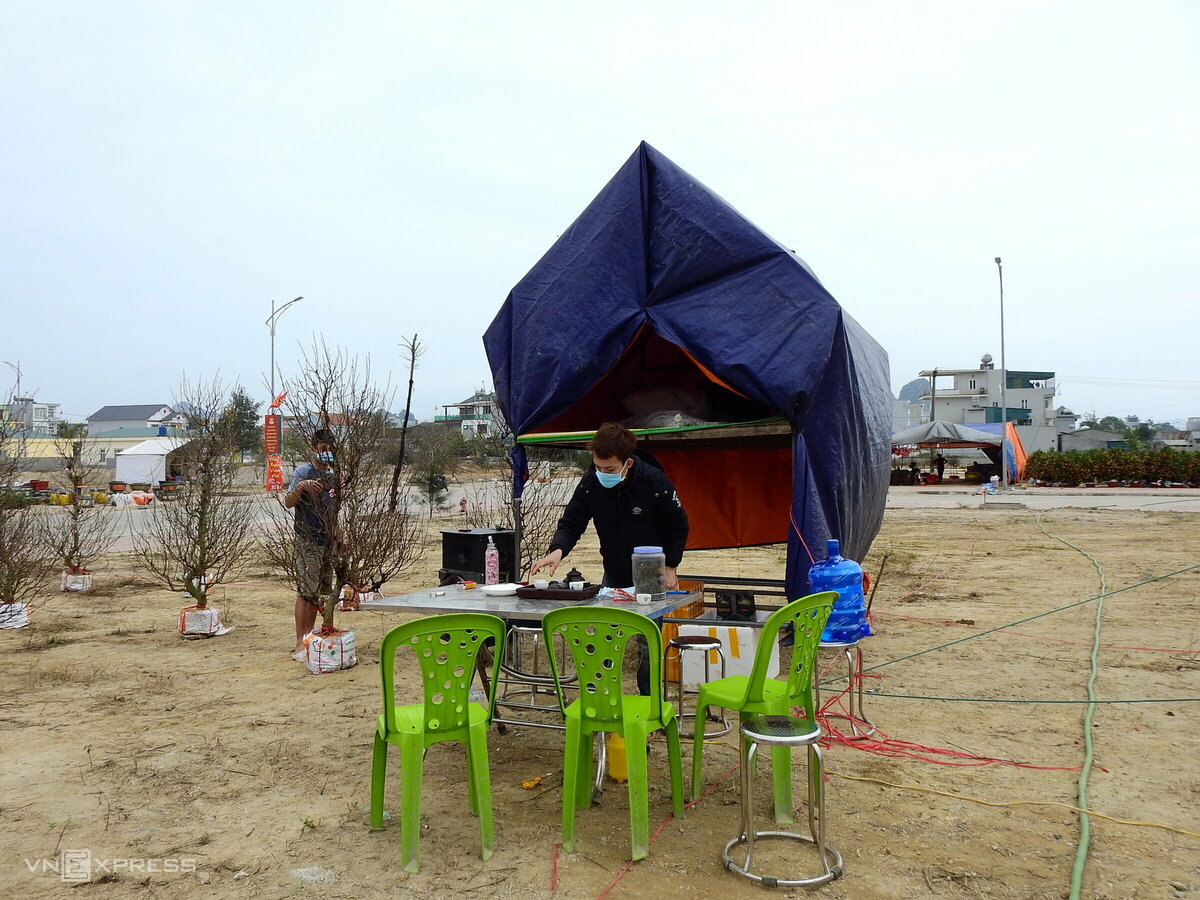 Khu vực chợ hoa ở thị trấn Cái Rồng cũng vắng khách. Anh Hoàng Văn Bình, 23 tuổi, quê Thanh Hóa, cho biết hôm 27/1 lên Đông Triều mua hơn 100 cây đào với giá khoảng 100 triệu đồng mang xuống Vân Đồn để bán, hôm sau nhận được thông tin có ca Covid-19, vì vậy mỗi ngày chỉ vài người đến hỏi mua đào. “Vài ngày sau thị trấn bị phong tỏa, anh em làm lều tạm ở tại đây luôn. Mọi sinh hoạt rất bất tiện, nhiều lúc đi mua cơm cũng khó. Chắc Tết này sẽ không về được quê”, anh Bình nói.