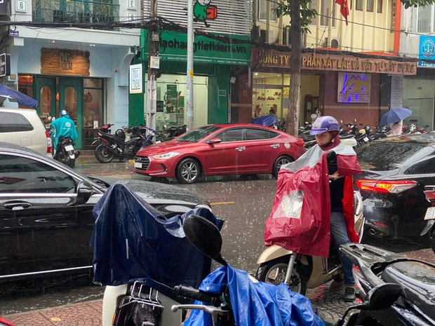 Mưa lớn khiến nhiều người phải mặc áo mưa khi ra ngoài
