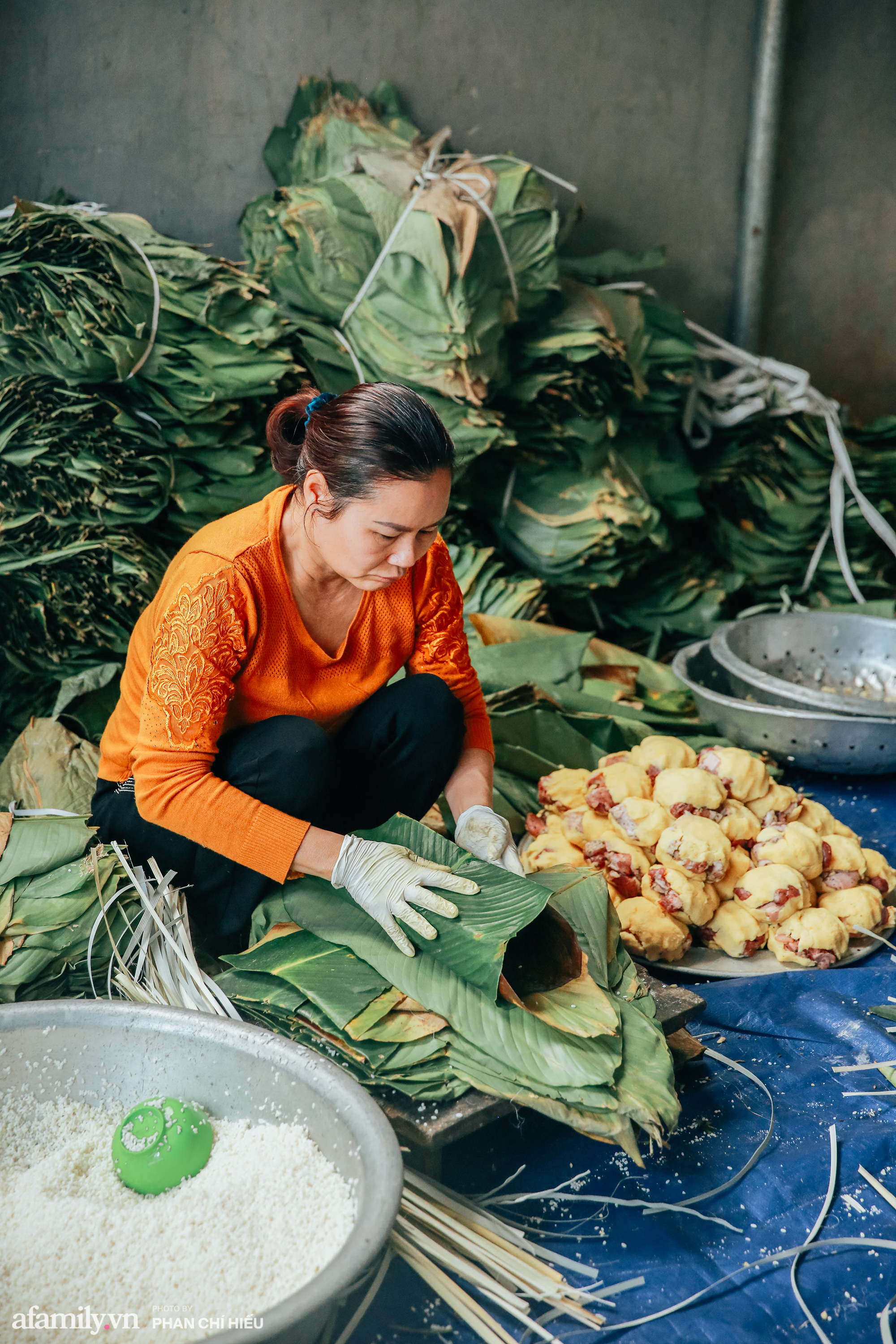 Làm nghề lâu năm, bàn tay người thợ khéo léo, cứ một lớp gạo, rồi một lớp nhân sau cùng lại một lớp gạo và rồi bánh được gói kín bằng những chiếc lá dong xanh mướt.