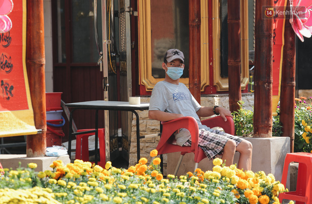 Người bán ngồi ủ rũ vì đường phố vắng người, ít khách mua hoa