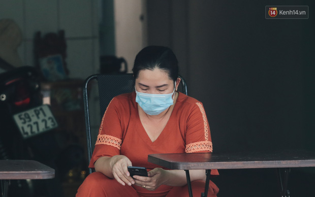 Người dân sống trên đường Nguyễn Phúc Chu đeo khẩu trang ngồi trước nhà