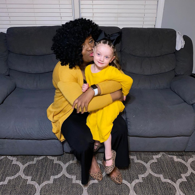 Bé Victoria tươi cười trong vòng tay của mẹ nuôi.