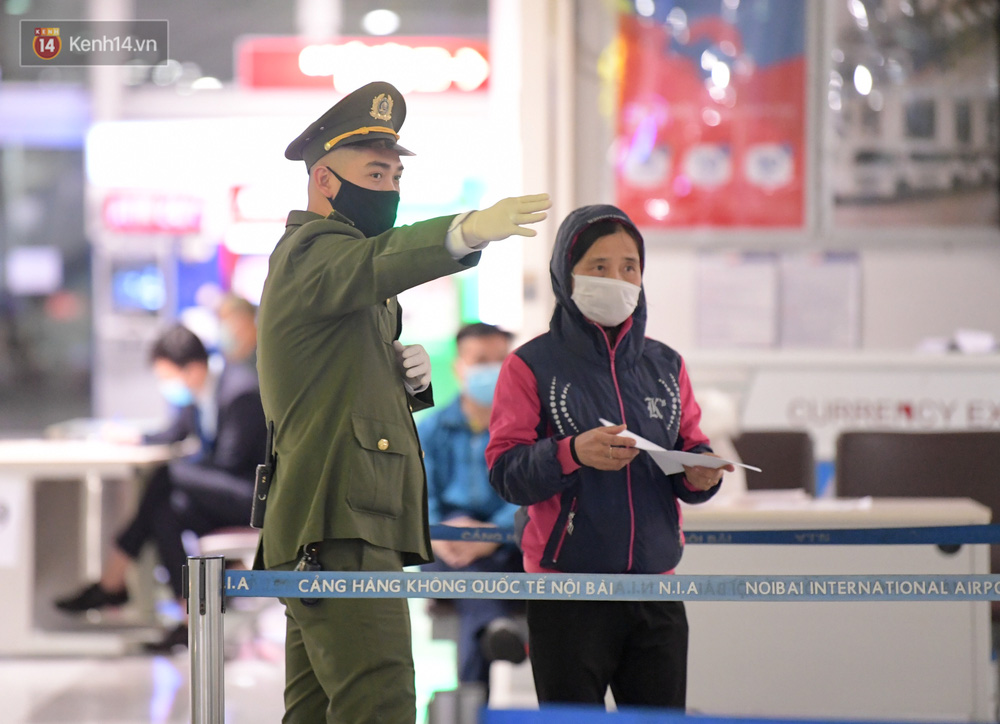 Lực lượng chức năng trong sân bay Nội Bài hướng dẫn người dân làm thủ tục xét nghiệm