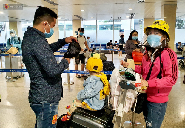 Một gia đình trang bị mũ chống giọt bắn để về quê, phòng dịch Covid-19