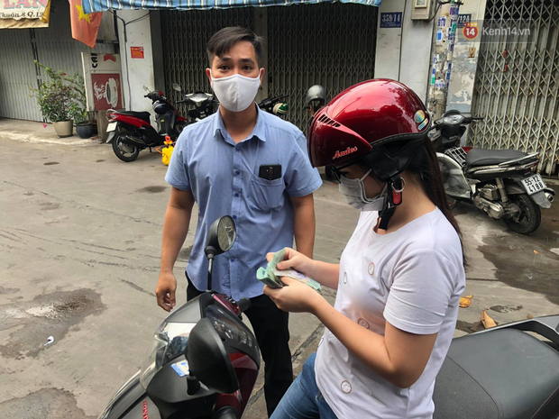 Mạnh thường quân và đại diện Mặt trận Tổ quốc quận ủng hộ tiền tiếp tế lương thực cho các hộ dân trong khu cách ly