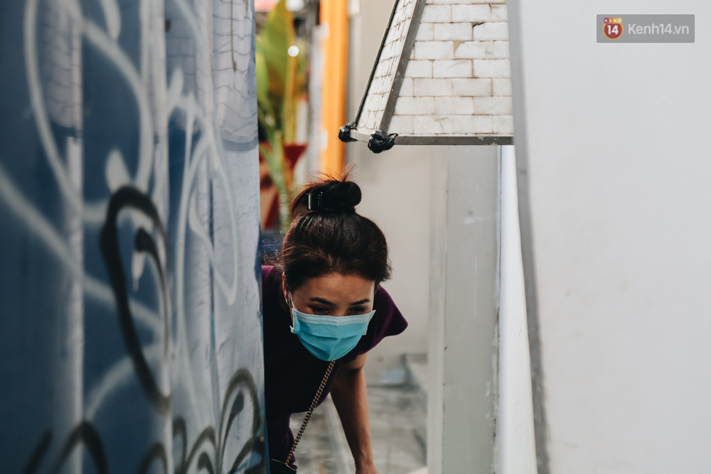 Người dân đi lại bên hàng rào phải cúi đầu, luồn lách qua khe hở bé xíu