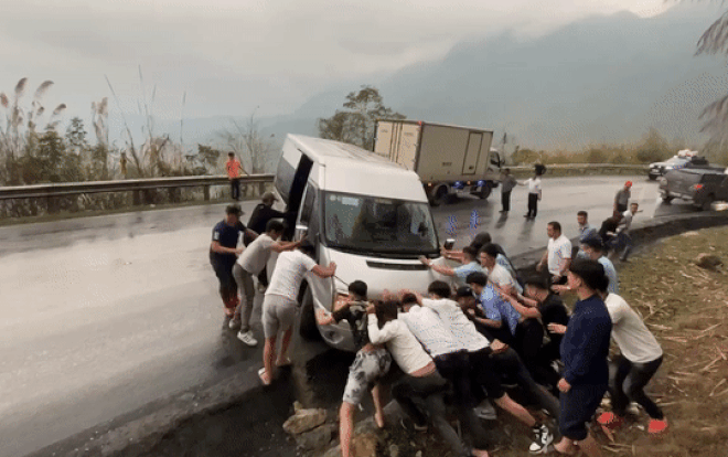 Cả chục người cùng hỗ trợ chiếc xe khách bị mắc kẹt