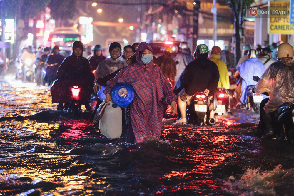Có người phải xuống lội bộ vì không thể ngồi trên xe do đường ngập nặng
