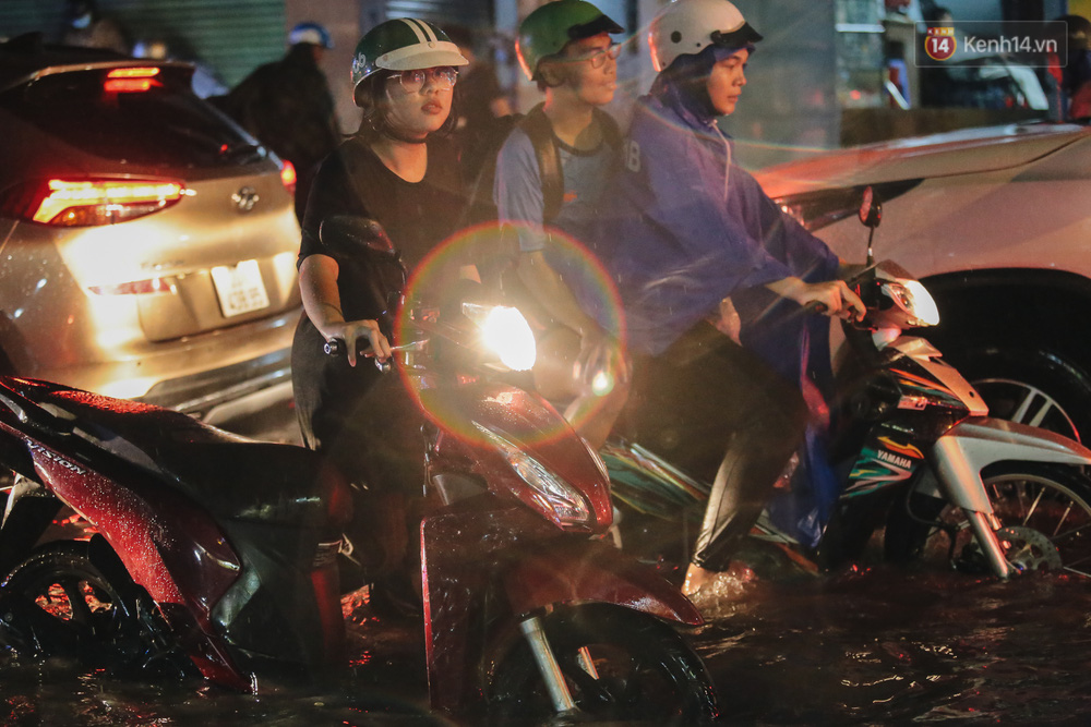 Cô gái lội bộ đẩy xe vượt đường ngập