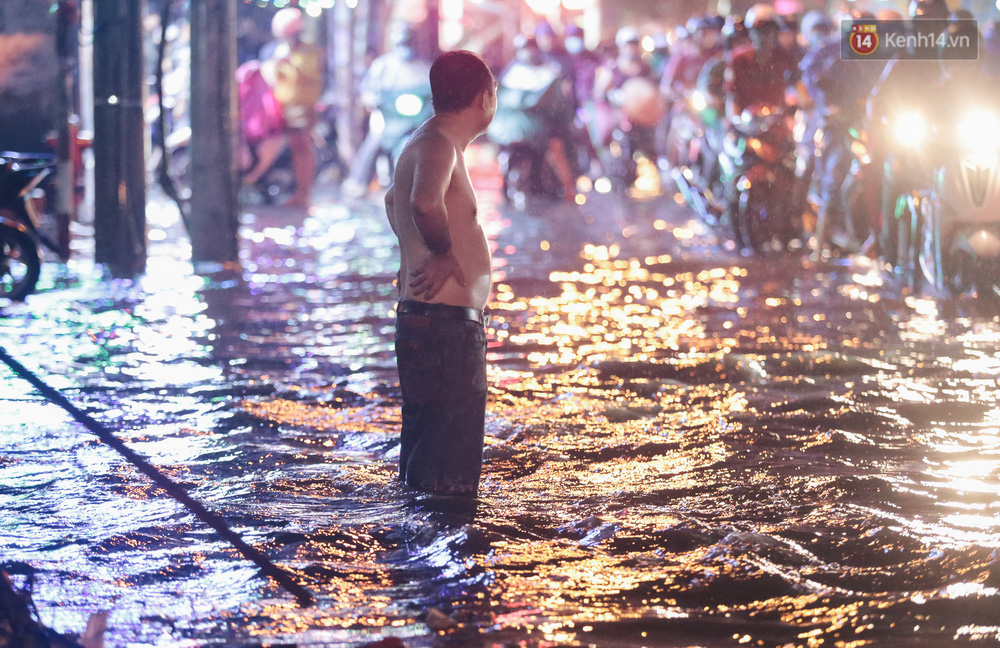 Sau đó người đàn ông này ra đứng tại điểm ngập nặng để cảnh báo, giúp đỡ người dân không đi vào điểm ngập sâu, nước chảy xiết