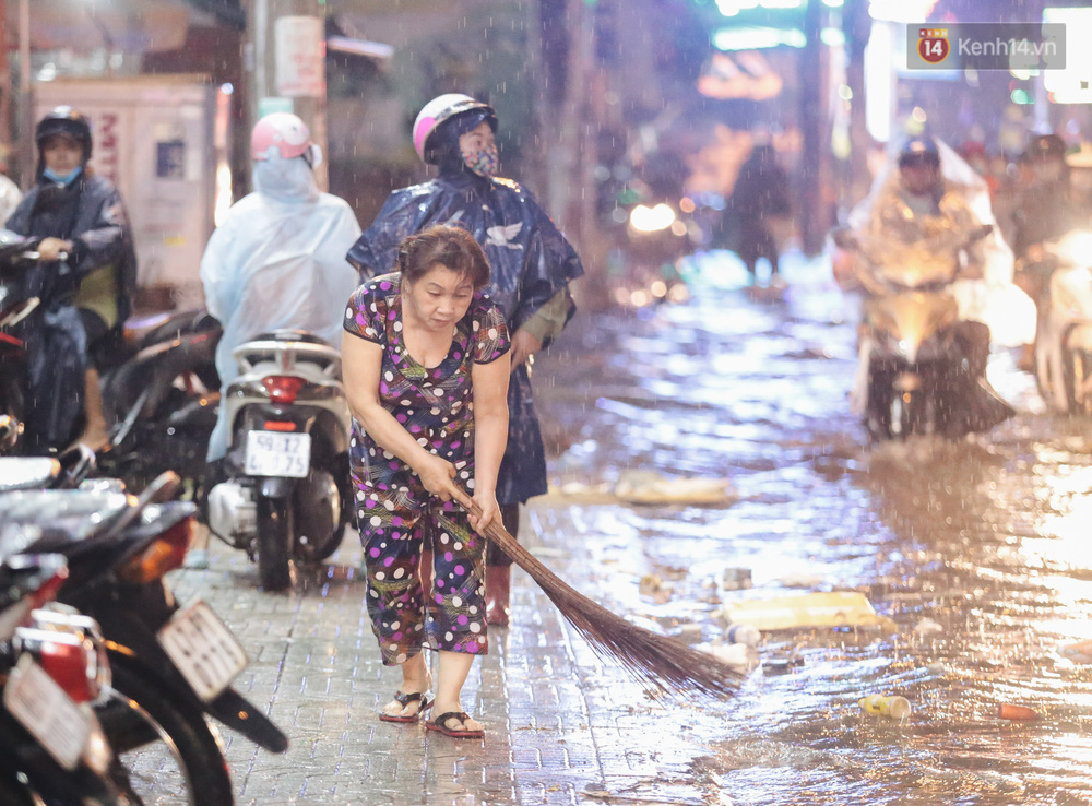 Người dân quét dọn rác sau khi mưa tạnh