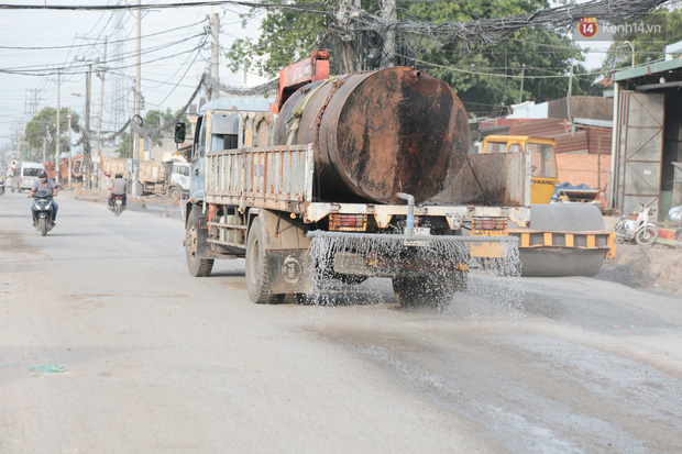 Thỉnh thoảng xe chở nước tưới mặt đường cho đỡ bụi nhưng chỉ giảm được một phần