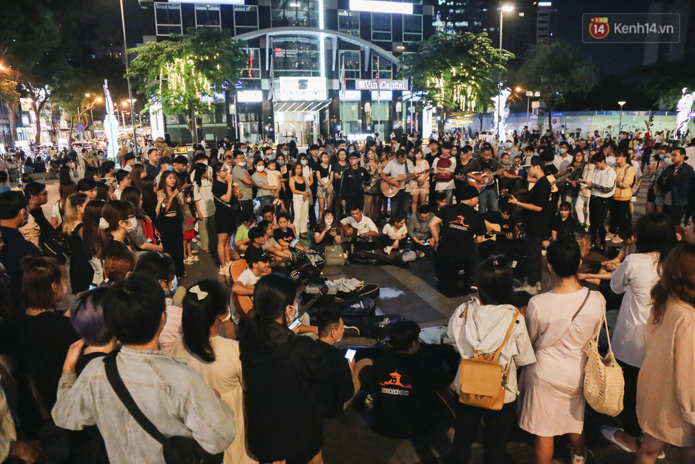 Các bạn trẻ tập trung lại một chỗ trên phố đi bộ để xem biểu diễn âm nhạc đường phố