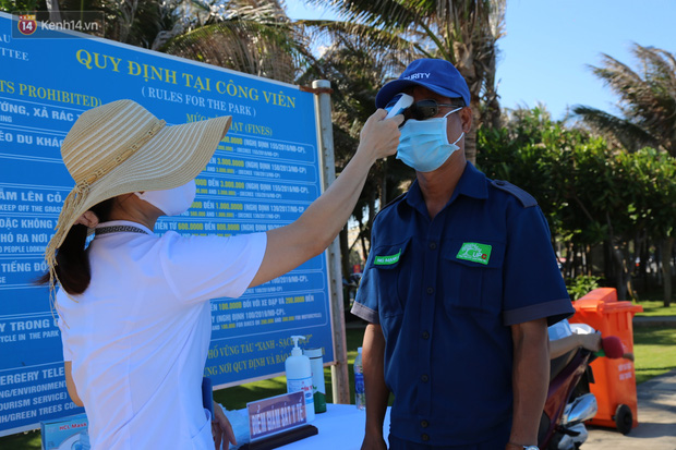 Lực lượng y tế đo thân nhiệt cho người dân khi xuống biển