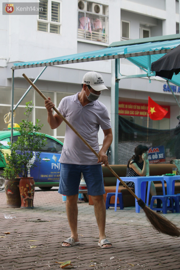 Anh T. một người bán trà đá (trú Cầu Giấy, Hà Nội) đang dọn nốt số rác. Anh cho biết, bán nước là công việc chính của anh, hiện anh đang nuôi 2 con độ tuổi đi học, nhưng với trách nhiệm chung tay chống dịch, anh đã tuân thủ đúng thời gian quy định