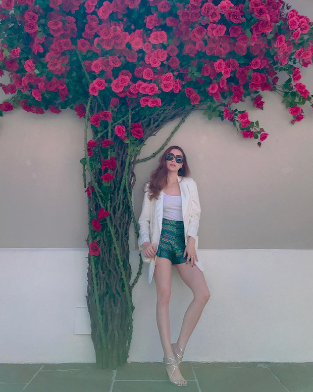 Chiếc quần shorts màu xanh ánh kim đã tạo điểm nhấn siêu nổi bật cho outfit. Và để đảm bảo độ hài hòa của tổng thể trang phục, Hà Hồ đã mix mẫu quần màu mè này với những items màu trung tính nhã nhặn, bao gồm áo thun, blazer đồng màu trắng, đôi sandal quai mảnh màu bạc đơn giản nhưng ấn tượng