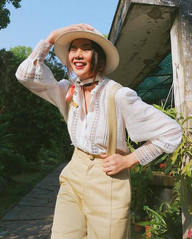 Thanh Hằng trẻ trung và retro khi phối áo blouse đục lỗ với quần yếm dây màu vàng pastel. Để outfit thêm phần màu sắc, cô còn cột khăn turban ở cổ và đội thêm chiếc nón cói xinh xắn. Outfit này lý tưởng nhất để đi picnic cuối tuần cùng bè bạn, vừa thoải mái năng động lại xinh yêu hết chỗ chê!